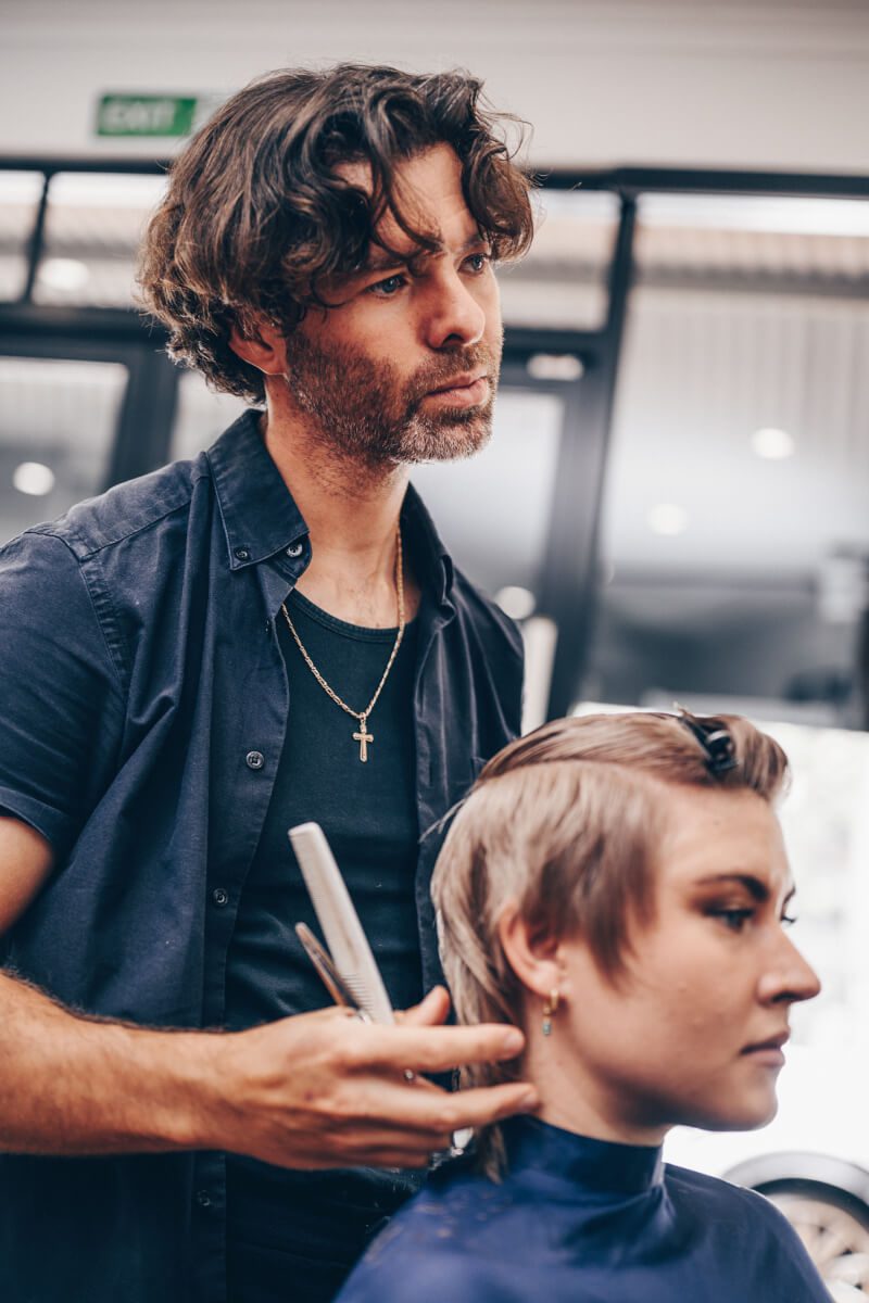 Tim working carefully on a client’s haircut