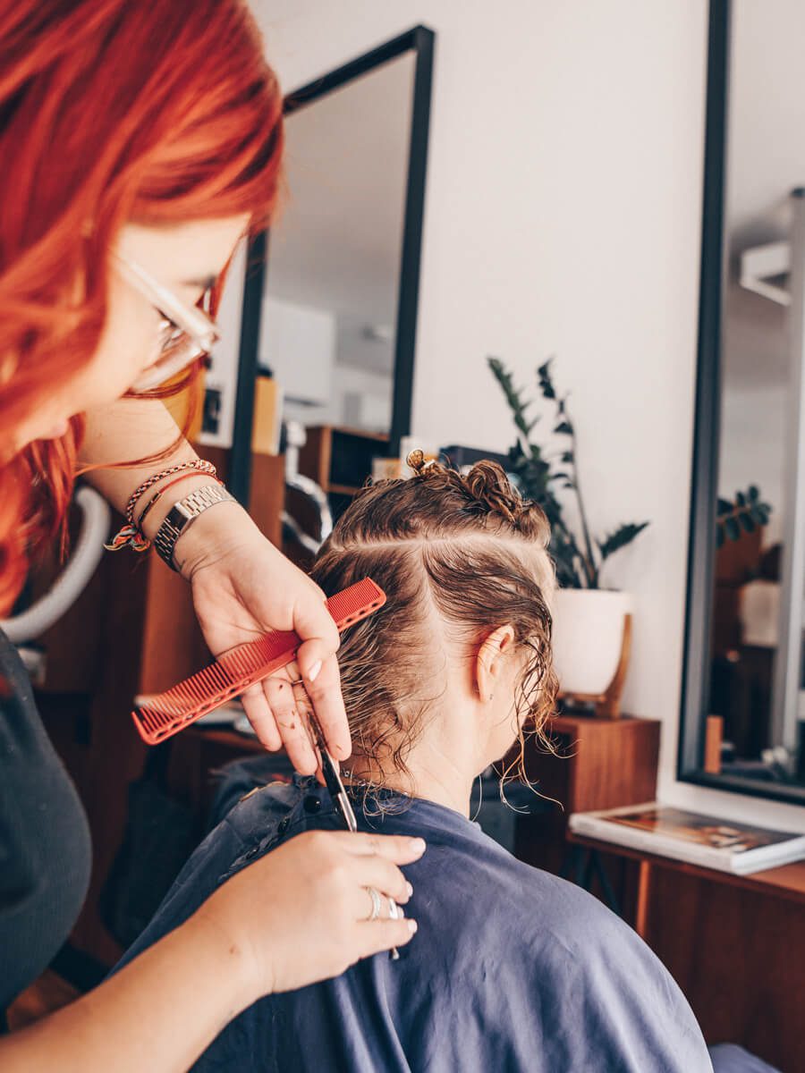 A stylist shaping a client’s haircut at Juicy Golden