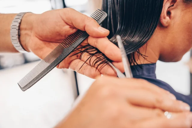Scissors and comb shaping a precise haircut at Juicy Golden